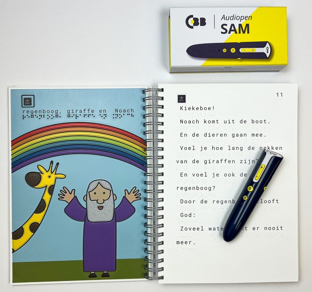 Afbeelding van 2 pagina's van de Peuterbijbel met aan de linkerkant een voelbare afbeelding van Noach en de regenboog en een giraffe. En aan de rechterkant het verhaal over Noach in grootletter en braille, en op het boek liggend de leespen SAM.